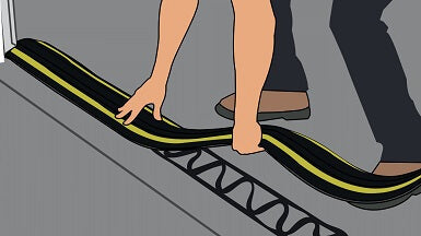 A man fitting a 50mm flood barrier threshold kit down with GaraDry adhesive