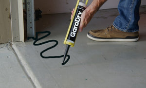 Man applying GaraDry adhesive & sealant to the garage floor