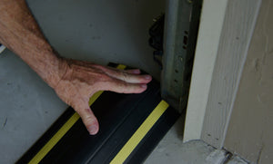 Hand installing the garage door flood barrier Garadam to the garage door