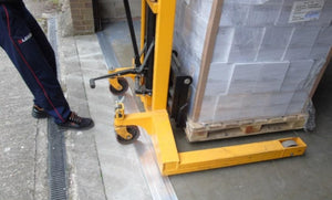 A pallet stacker going over a Industrial Strength Aluminum Threshold Seal