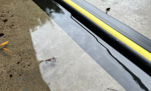 Close up of the ½" Garage door trade coil seal showing it stopping water from coming into a garage